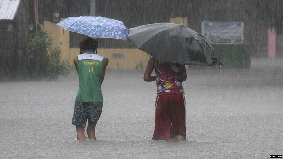 Residents wade across floodwaters caused by Typhoon Goni in Bacnotan, La Union, in northern Philippines 22/08/2015