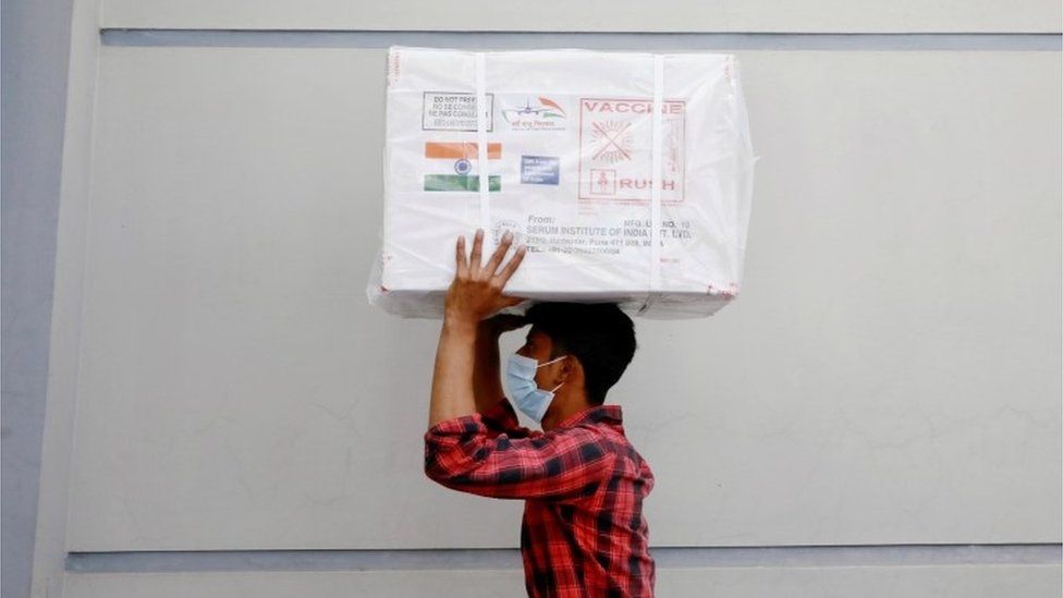 A worker carries a package of Oxford-Astrazeneca COVID-19 vaccines that arrived from India as a gift to Bangladesh, in Dhaka, Bangladesh January 21, 2021