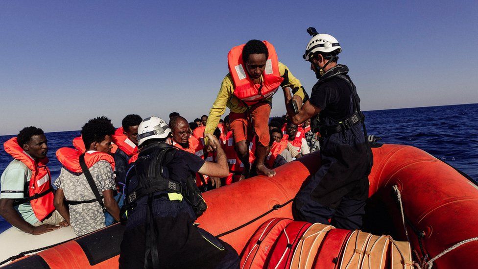 Migrants getting on life rafts