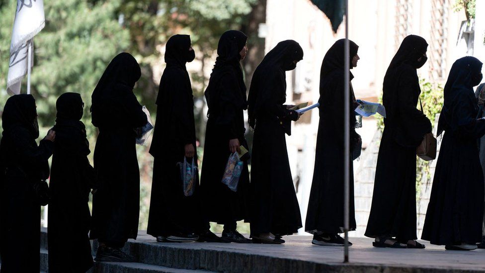 Afghan female students stand in a queue after they arrive for entrance exams at Kabul University in Kabul on 13 October 2022