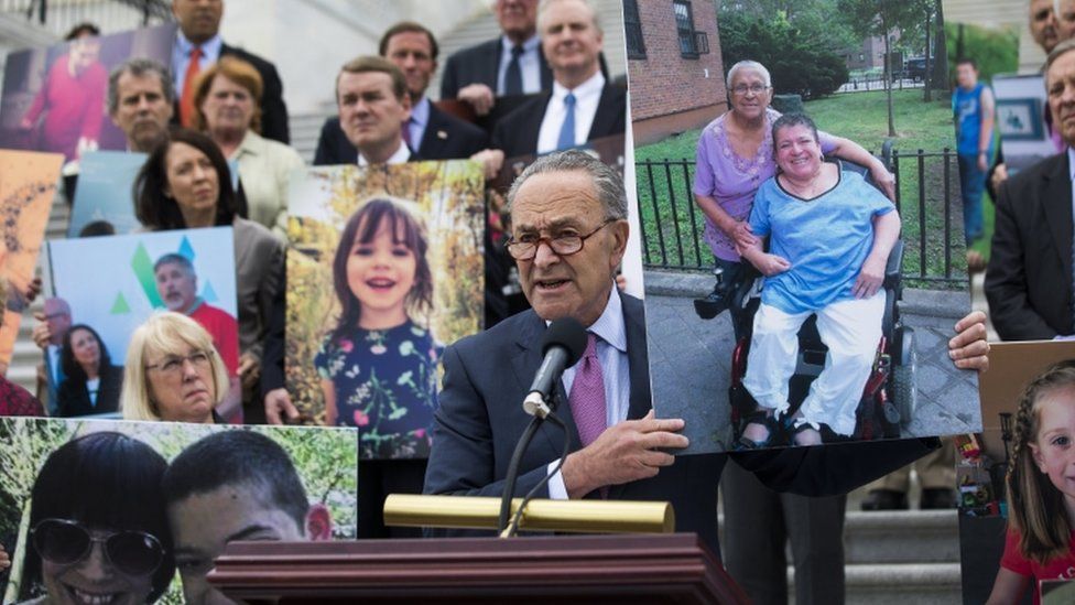 Democrats held photos of patients during a press conference on the Capitol steps to oppose the bill
