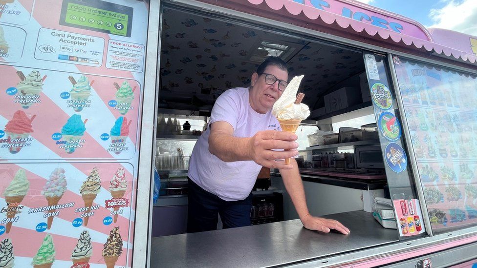 Lawrence Glauser in his ice cream van holding a 99 ice cream