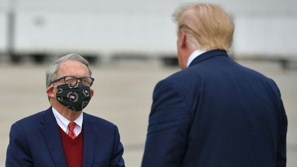 US President Donald Trump speaks with Ohio Governor Mike DeWine upon arrival at Rickenbacker International Airport in Columbus, Ohio on October 24