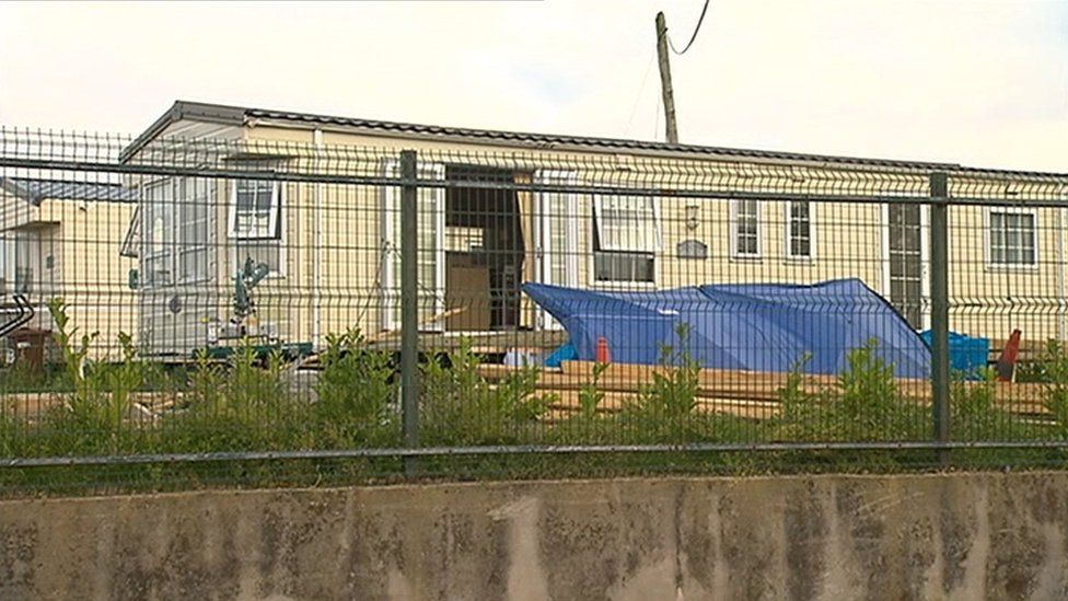 A forensic examination tent at the scene of the shooting beside a caravan