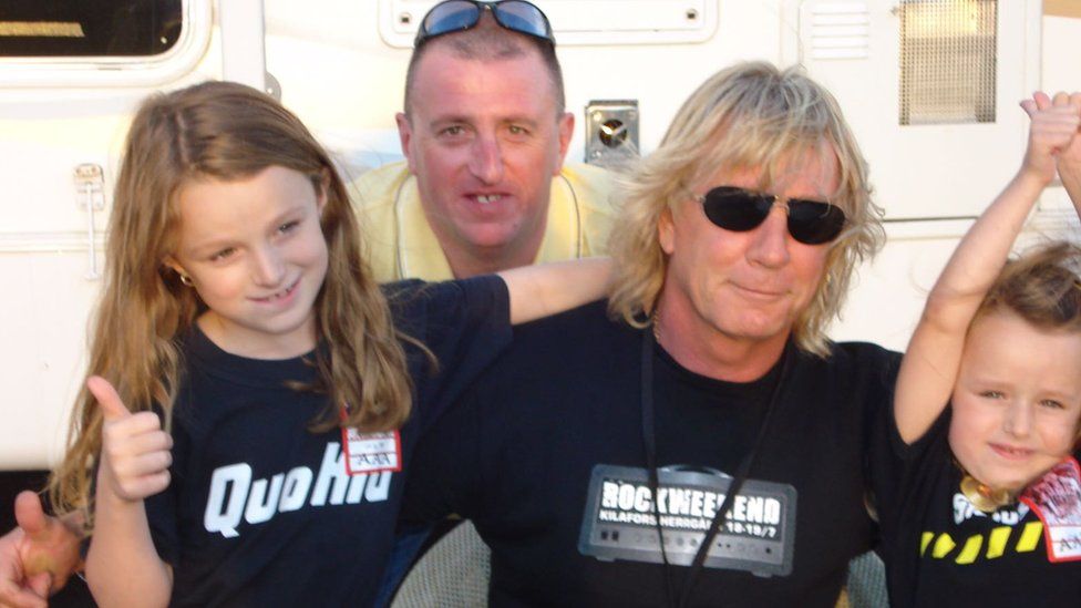Mark Bickley with his daughters pose with Rick Parfitt in 2008