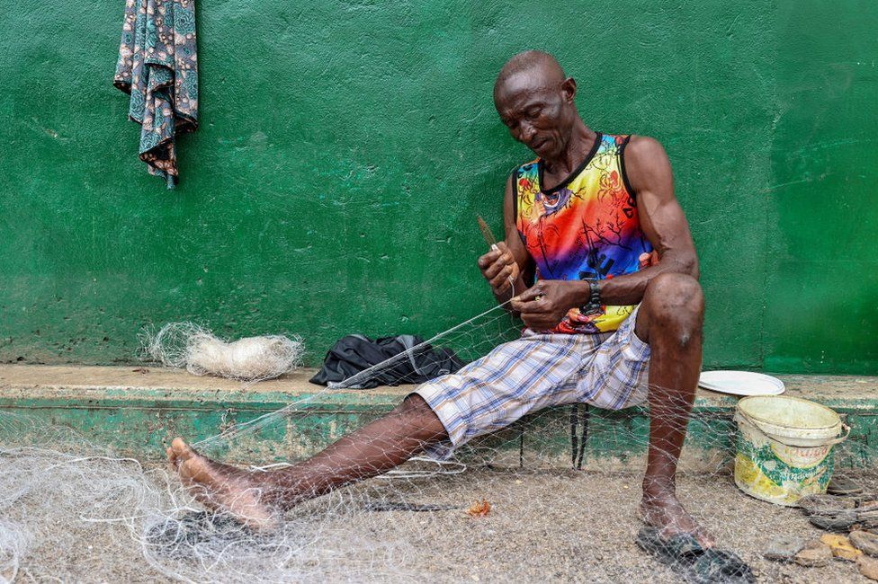 A man works on a fishnet in Conakry, Guinea.