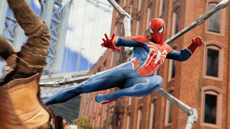 An action shot from Spider-Man 2 of the superhero flying through the air, kicking an enemy to the ground. Spider-Man has articulated spider legs emerging from his back, and the enemy, wearing a light brown jacket with dark brown arms, has his arms up over his head as he falls to the ground.