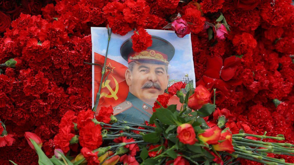 A portrait of Soviet leader Joseph Stalin and flowers are placed on his grave