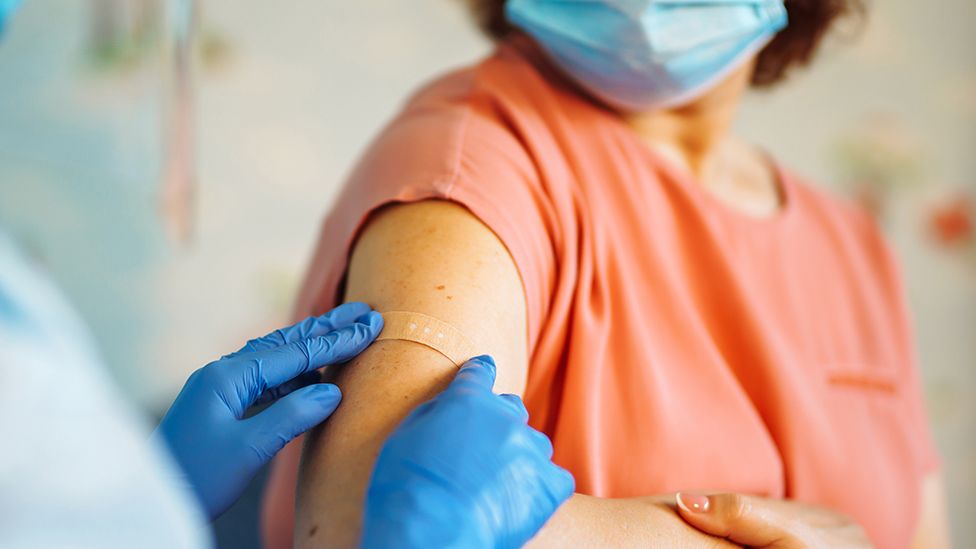 Medic applying plaster following vaccination