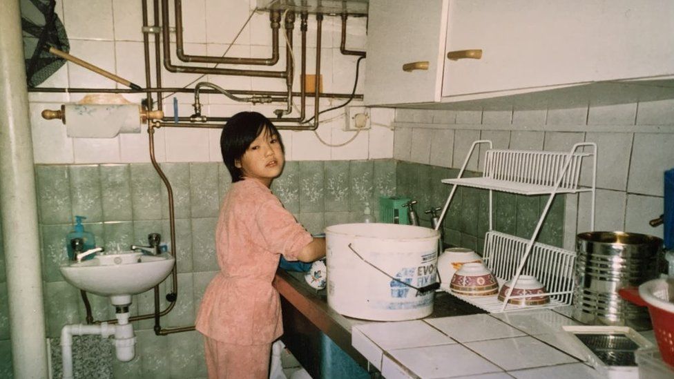 Angela washing dishes in the takeaway in 2001