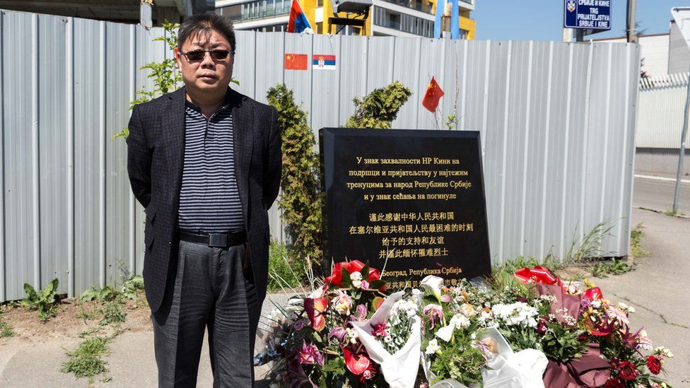 Shen Hong stands in front of the memorial