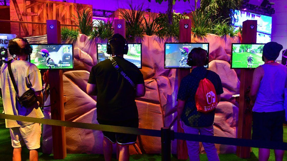 Four gamers play Fortnite on a busy stand at the E3 2018 conference in LA