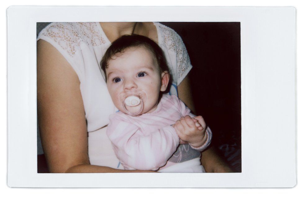 A polaroid photo of Angela with her baby