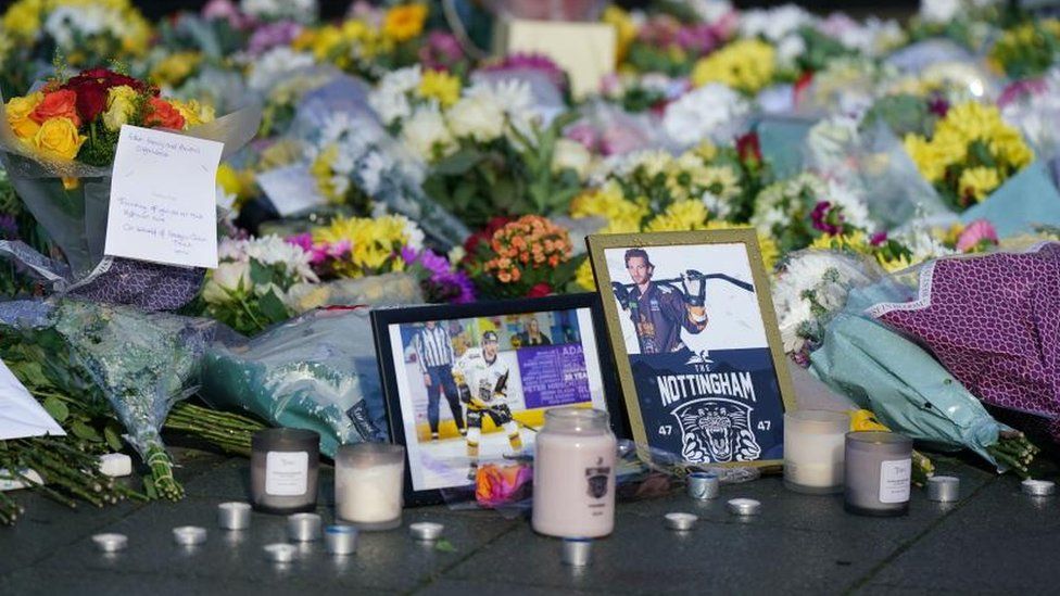 Lit candles among the flowers and messages left in tribute to Nottingham Panthers' ice hockey player Adam Johnson