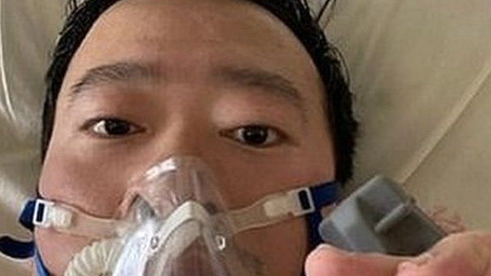 Dr Li posts a picture of himself in a gas mask from his hospital bed on Friday