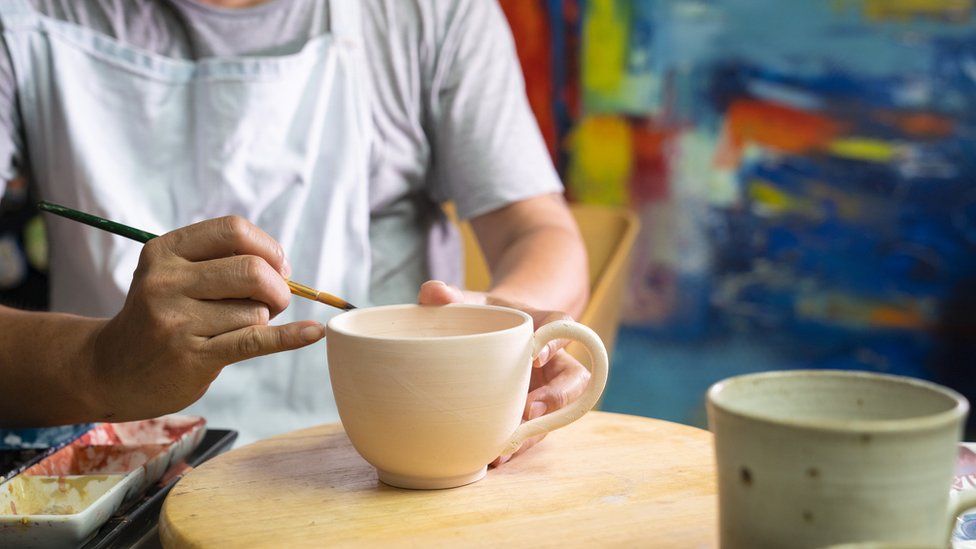 Generic shot of a man taking part in a pottery course