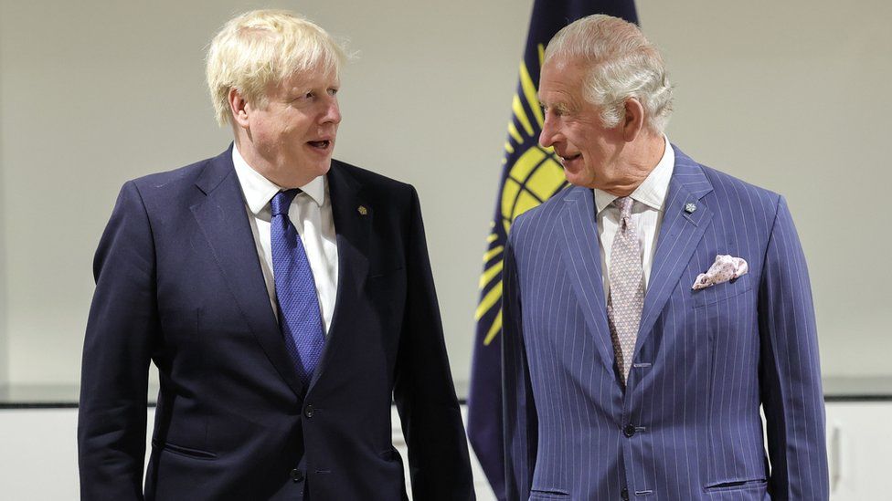 Boris Johnson and Prince Charles stand side by side in conversation with one another
