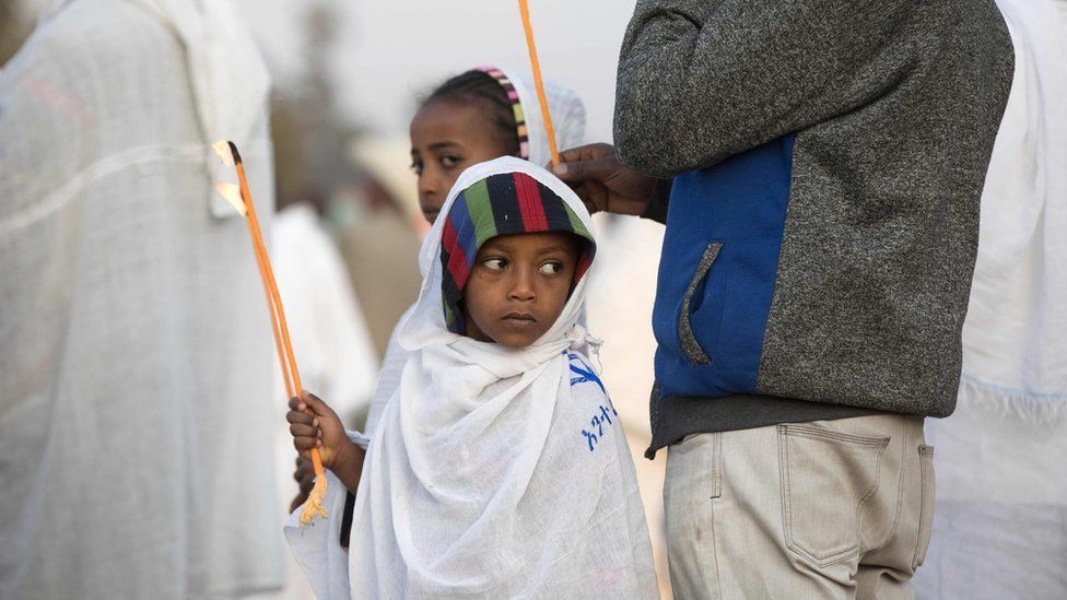 A young boy holds a candle during the Timket, an Epiphany festival, in Addis Ababa, on January 19, 2018.
