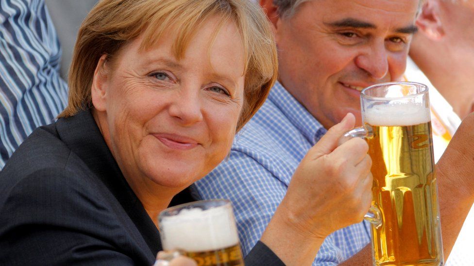 Kancelarja gjermane Angela Merkel (L) dhe Peter Mueller, kryeministër federal i rajonit Saar dhe kandidati kryesor i partisë konservatore të Unionit Kristian Demokratik (CDU) për zgjedhjet e ardhshme të shtetit Saarland, mbajnë gota birrë gjatë një tubimi të fushatës elektorale në Bosen pranë Saarbruecken 15 gusht 2009