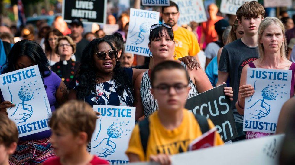 A march in Minneapolis in 2017 with protestors holding placards saying "Justice for Justine"