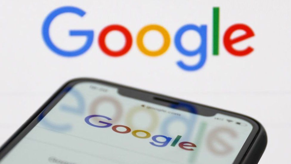 Google Search displayed on a smartphone against a Google logo background