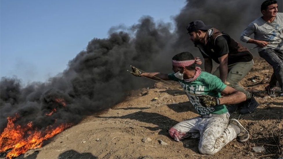 Palestinian prepares to fire a slingshot at a Gaza border protest (15/05/18)