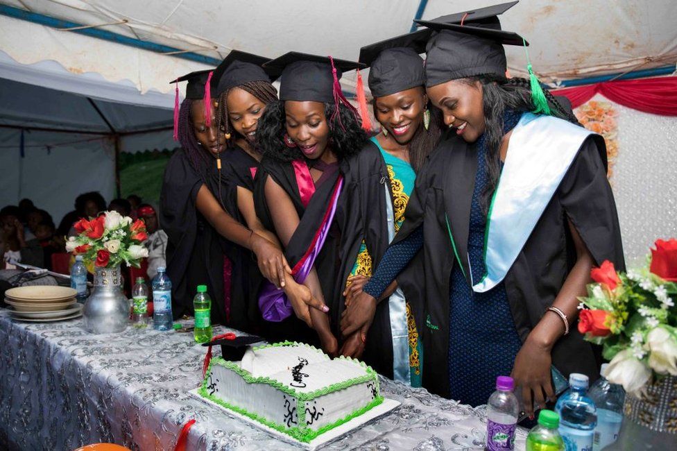 Ruth Akulu (right) and colleagues cut a cake together.