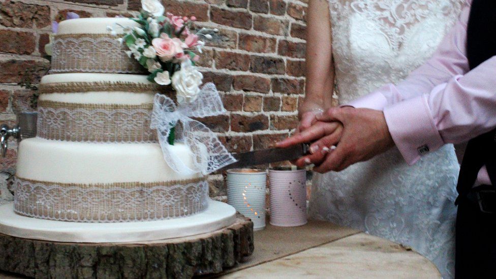 Newly-weds cutting a wedding cake