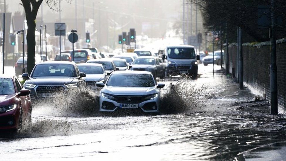 Cars drive through floodwater in Manchester
