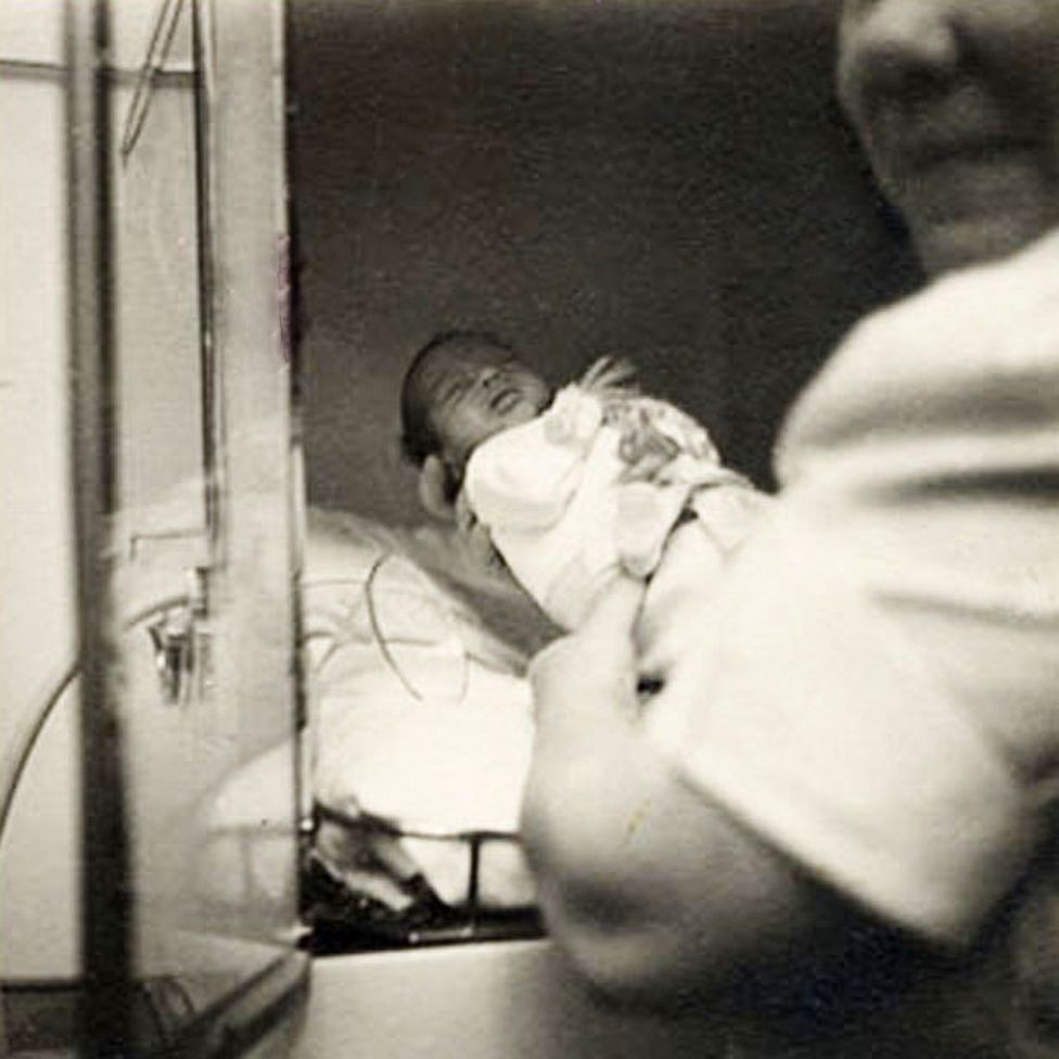 A baby being placed into one of Dr Couney's incubators