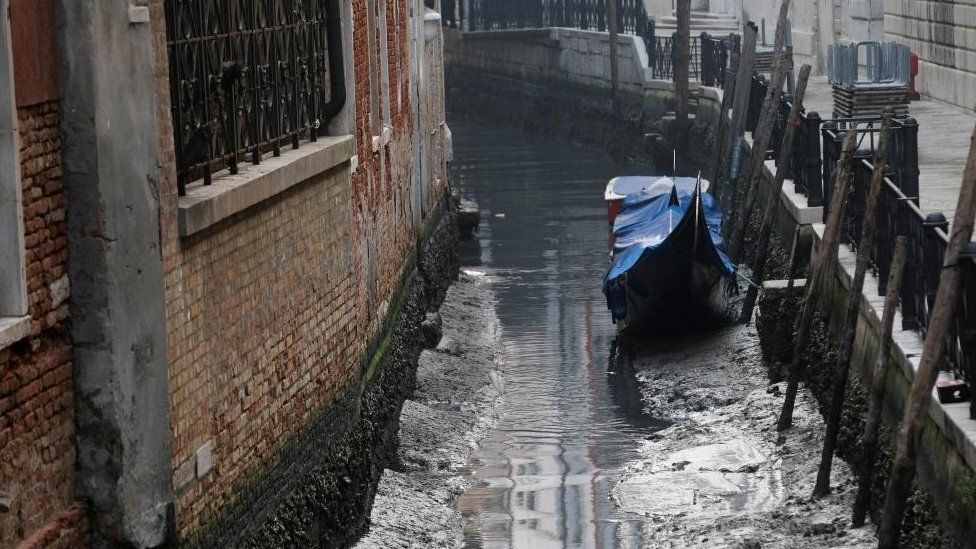 Eine Gondel ist in einem Kanal während einer schweren Ebbe in der Lagunenstadt Venedig, Italien, am 17. Februar 2023 abgebildet