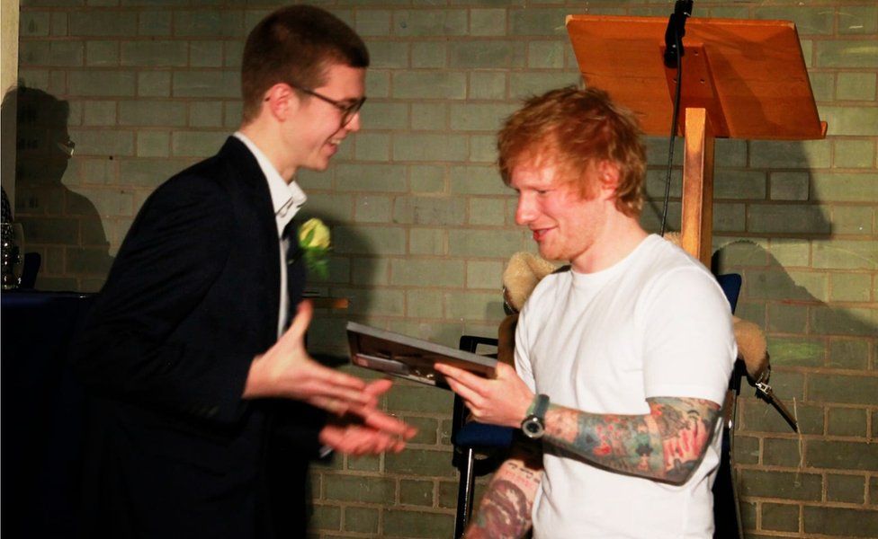 Tom Turner being presented with his award by Ed Sheeran