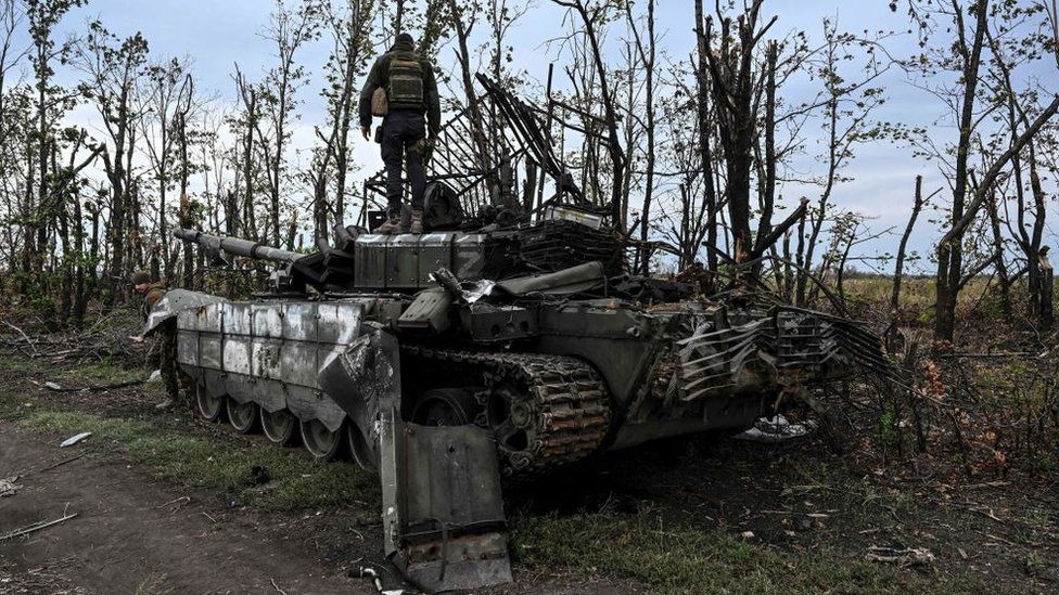 photograph taken on September 11, 2022, shows a Ukranian soldier standing atop an abandoned Russian tank near a village on the outskirts of Izyum, Kharkiv Region, eastern Ukraine, amid the Russian invasion of Ukraine