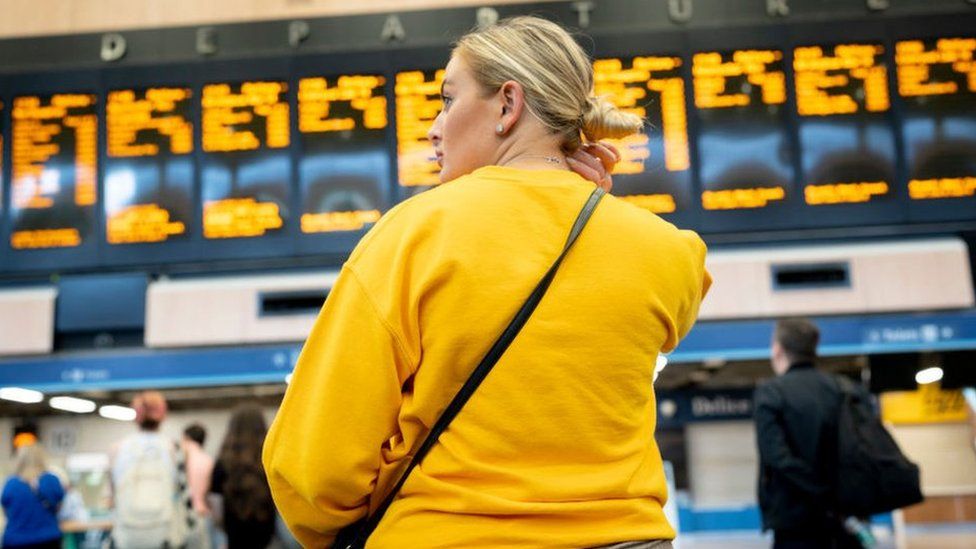 Женщина смотрит на расписание поездов