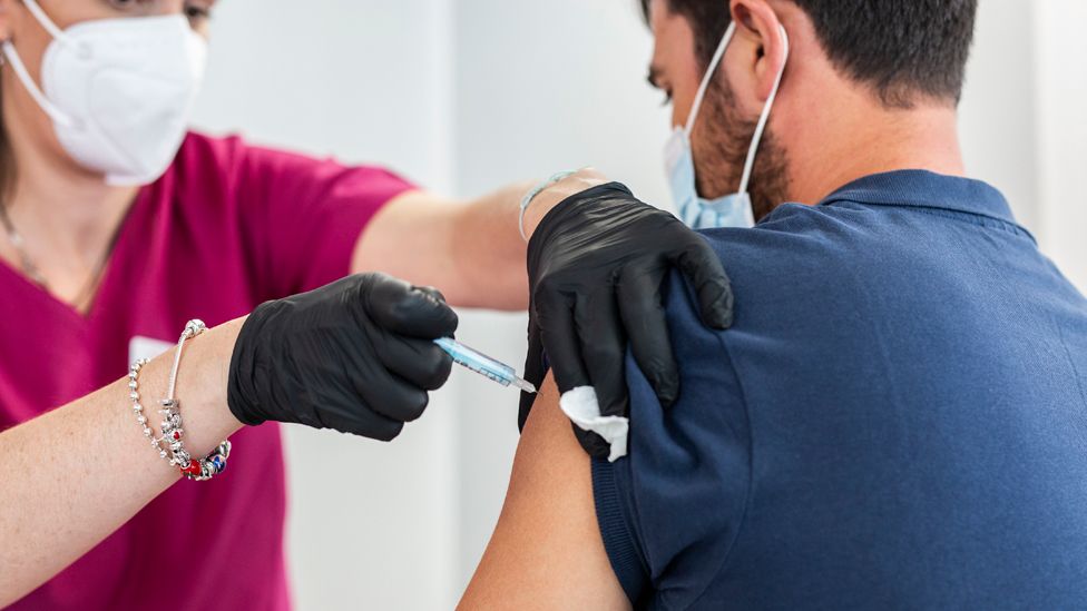 Человек получает вакцину Moderna против Covid-19 в устройстве, выпущенном Acciona в Мадриде 5 июля 2021 г.