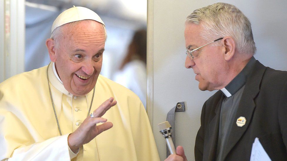 Pope Francis (L) talks with Father Federico Lombardi as he arrives to welcome the journalists on board the flight to Ecuador's capital Quito on 5 July, 2015.