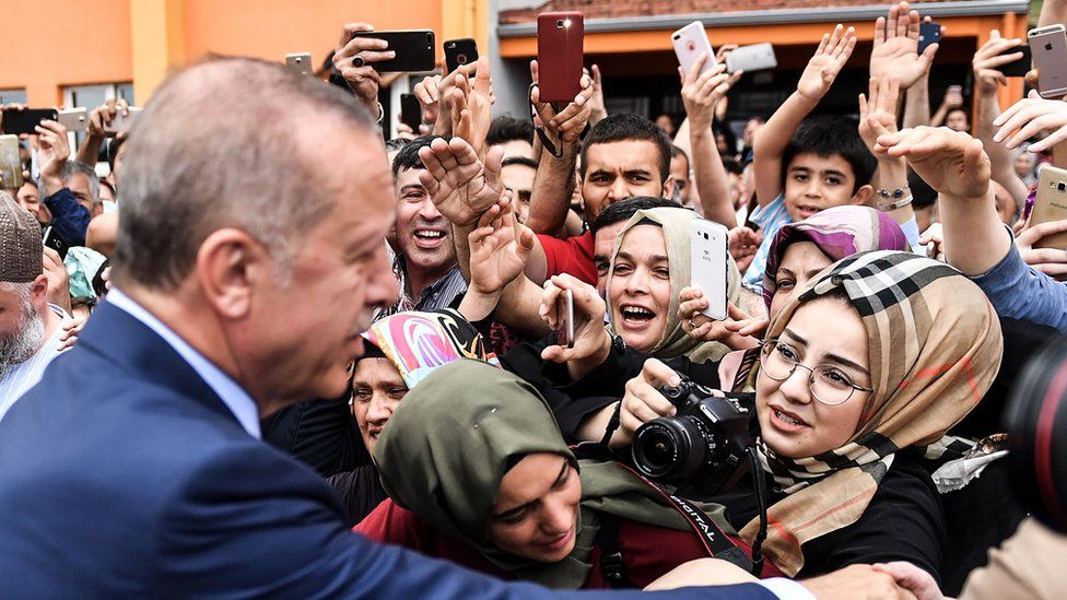 President Recep Tayyip Erdogan, leader of the Justice and Development Party (AKP), is greeted by supporters as he leave the polling station after casting his vote