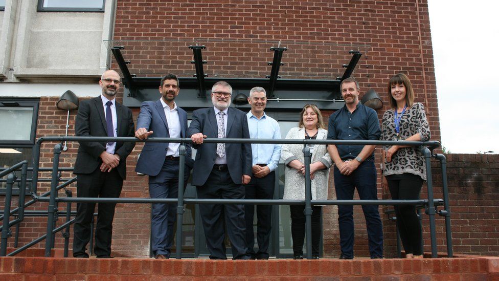 Mayor Dave Hodgson (third from left) with council officers and partners standing in front of Roger’s Court, an emergency accommodation centre in Bedford