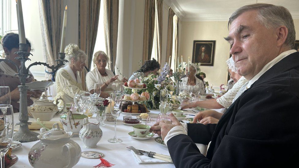 Diners in Regency outfits sitting at a table