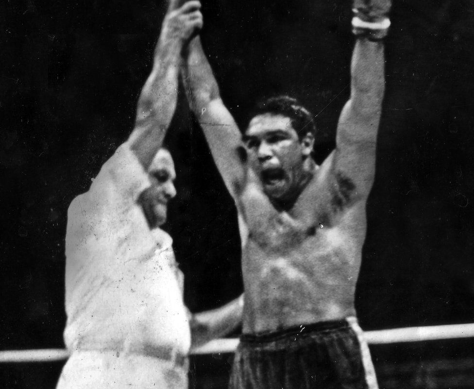 Wally Carr's arm is held up afer winning a bout