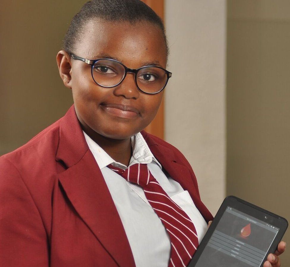 Caroline poses with a tablet in her school uniform