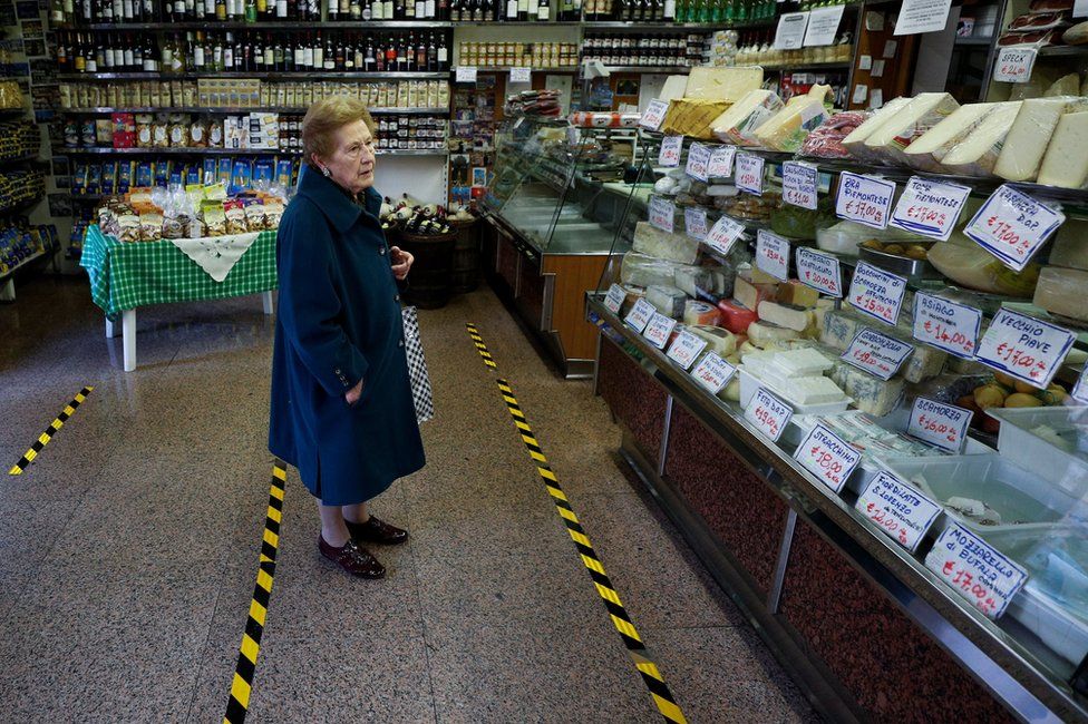 A lady waits to be served in a food shop