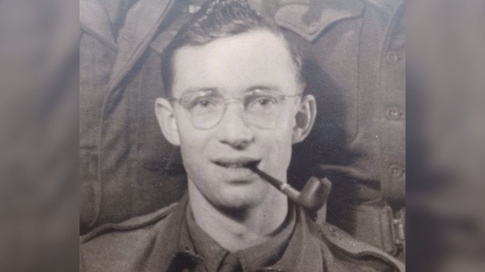 Dennis Lanham as a young man in uniform smoking a pipe