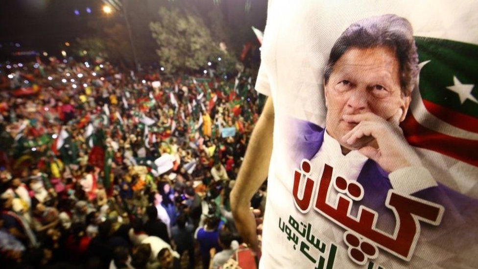 A protester wears an Imran Khan supporter shirt at a rally in Karachi on Sunday night