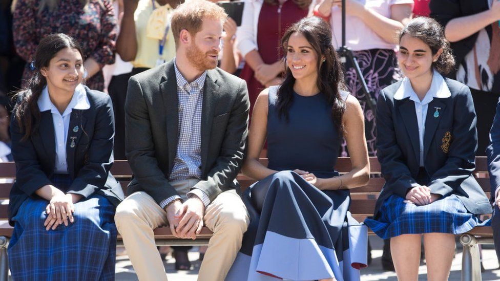 Meghan Markle and Prince Harry sit with some school girls
