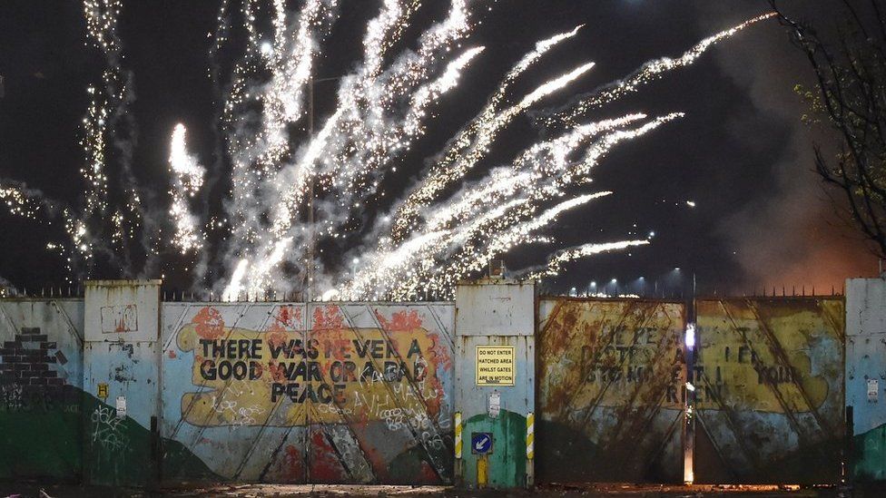 A firework exploding over a peace wall in west Belfast