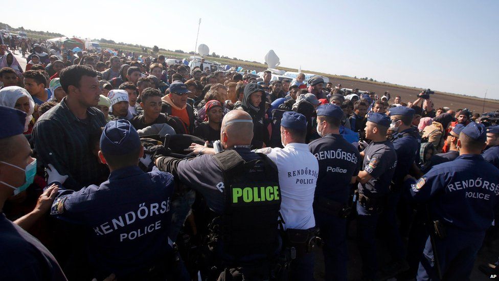 Police try to prevent migrants in Roszke, southern Hungary, leaving a makeshift camp for asylum seekers on Wednesday - many later broke through the police lines