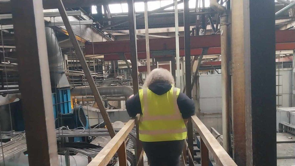 woman in high viz on gantry in factory