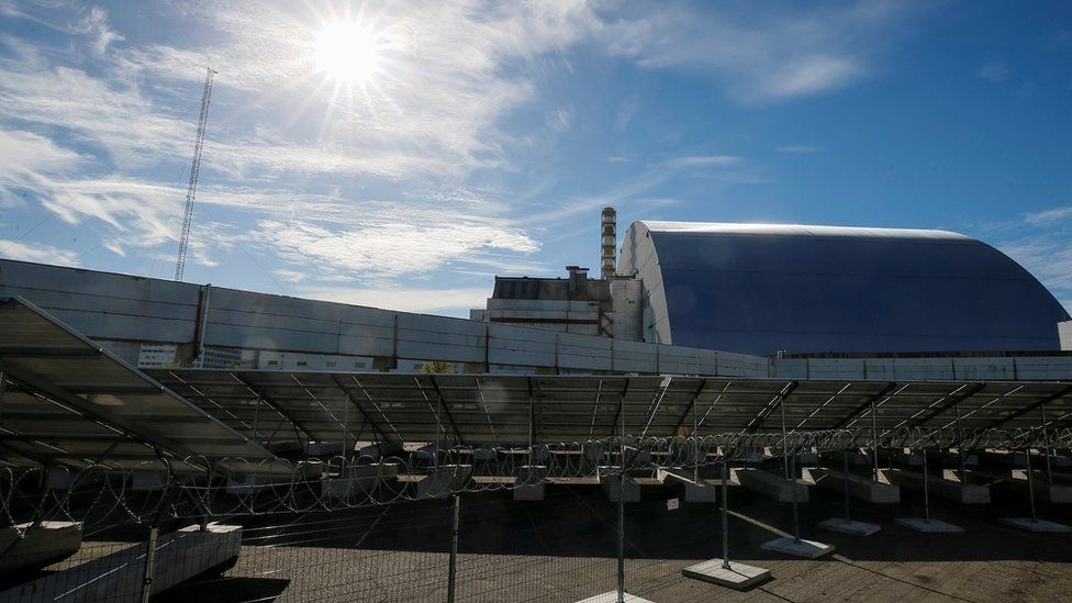 Sun shines on Solar panels in front of the the damaged fourth reactor of the Chernobyl nuclear plant, at solar power plant in Chernobyl, Ukraine on 5 October 2018.