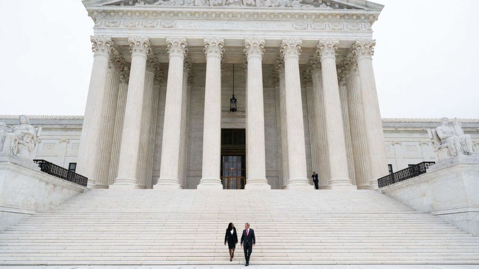 US Supreme Court Justice Ketanji Brown Jackson and Chief Justice John Roberts walk down the steps of the US Supreme Court, immediately following the investiture ceremony of Justice Jackson in Washington, DC, September 30, 2022